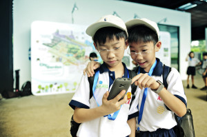 Twin brothers from Singapore teach each other how to access a next-generation mobile learning platform from the We Learn program.