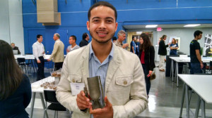 Alex Finch holds a cutaway of his team’s 3D-printed rocket engine. (Photo by Chris Jennewein)