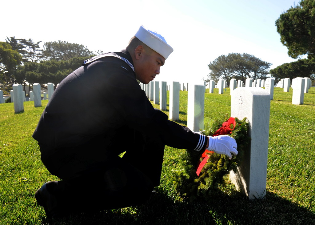 Hospital Corpsman 2nd Class Marlon Yulo, assigned to Naval Medical Center San Diego, places a wreath on a headstone during the 23rd annual Wreaths Across America Ceremony at Fort Rosecrans National Cemetery on Point Loma. In its 10th year of participation, Fort Rosecrans laid down 4,600 wreaths for fallen service members. (U.S Navy Photo by Mass Communication Specialist 2nd Class Kyle Carlstrom)