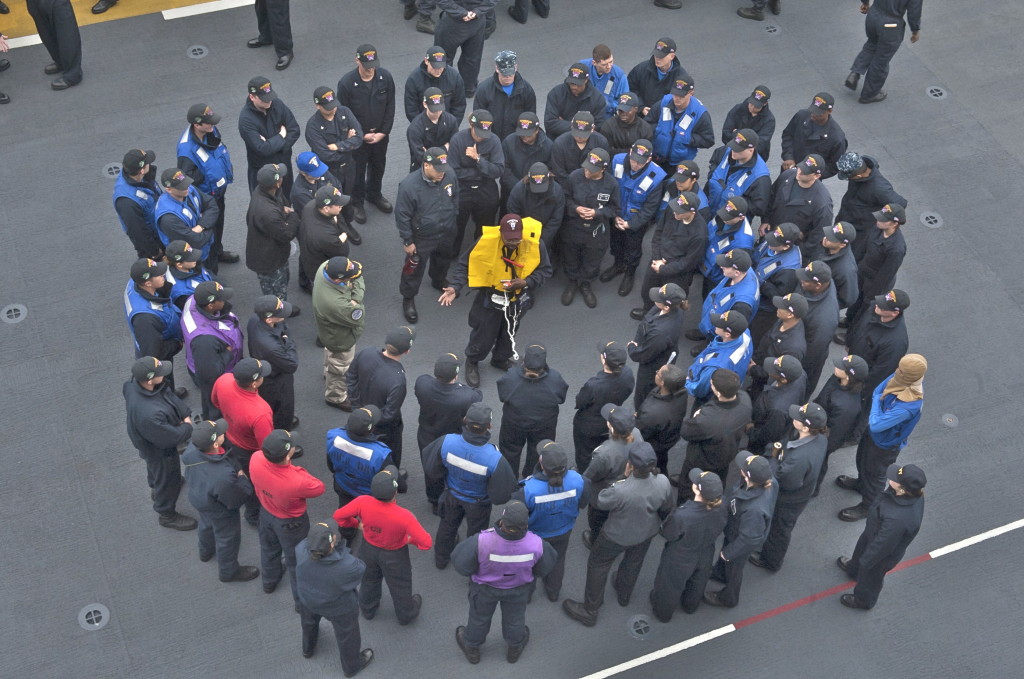 Boatswain's Mate 1st Class Johnathan Underwood, center, from Fayatt, Ala., demonstrates proper use of an inflatable life preserver to USS Makin Island sailors during an abandon ship drill. Makin Island is conducting operations off the coast of San Diego. (U.S. Navy Photo by Mass Communication Specialist Seaman Clark Lane)  