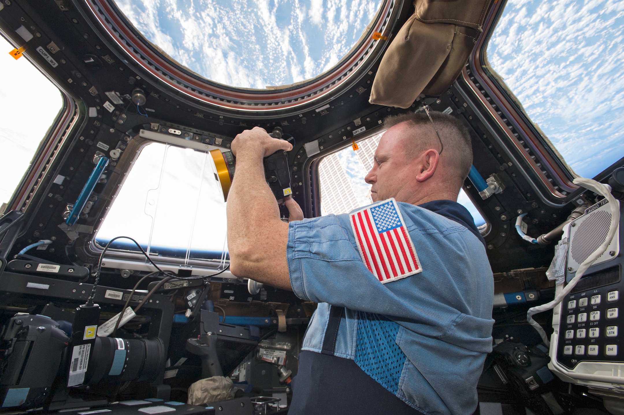 NASA Commander Barry ‘Butch’ Wilmore shoots a scene with the IMAX camera through the window of the International Space Station’s Cupola Observation Module. (Courtesy of NASA)