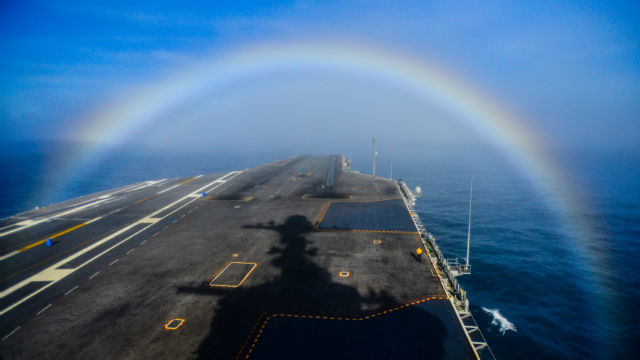 A rainbow forms over the bow of the Nimitz-class aircraft carrier USS John C. Stennis. (Navy photo by Mass Communication Specialist 3rd Class Ignacio D. Perez)