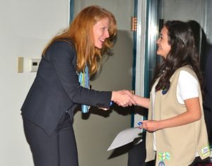 A Cadette Girl Scout from Los Angeles accepting a Girl Scout Silver Award from Carol Dedrich.