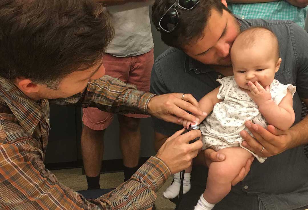 An infant has her fingerprint scanned with a new biometric identification device designed to make children’s vaccinations more efficient and more effective. (Credit: UCSD)