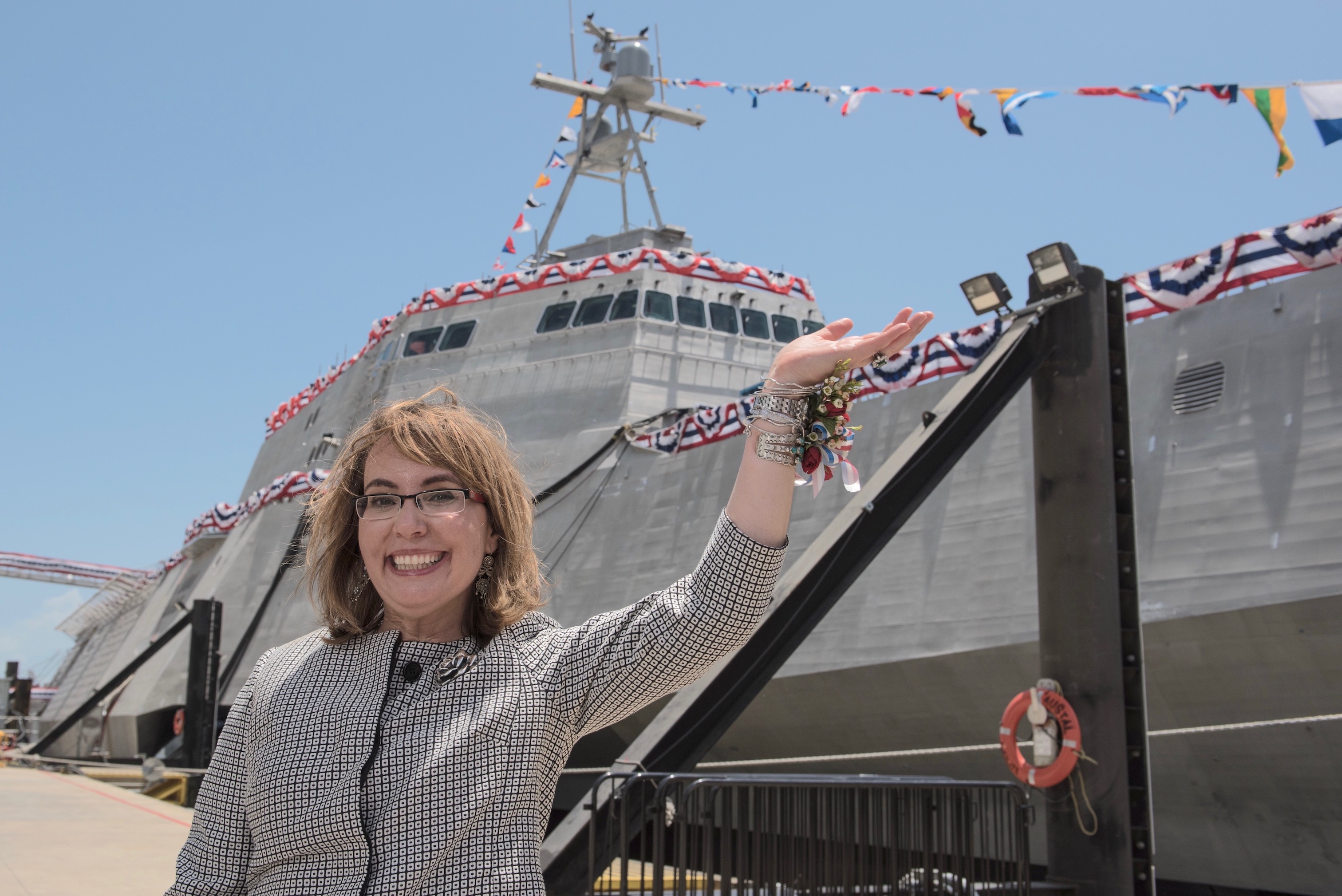 Former U.S. Rep. Gabrielle ‘Gabby’ Giffords waves to a crowd in front of the littoral combat ship USS Gabrielle Giffords,