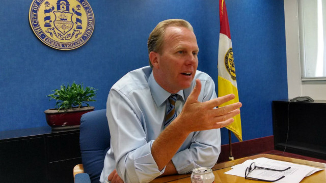 Mayor Kevin Faulconer with the city seal and flag in the background. (Photo by Chris Jennewein)
