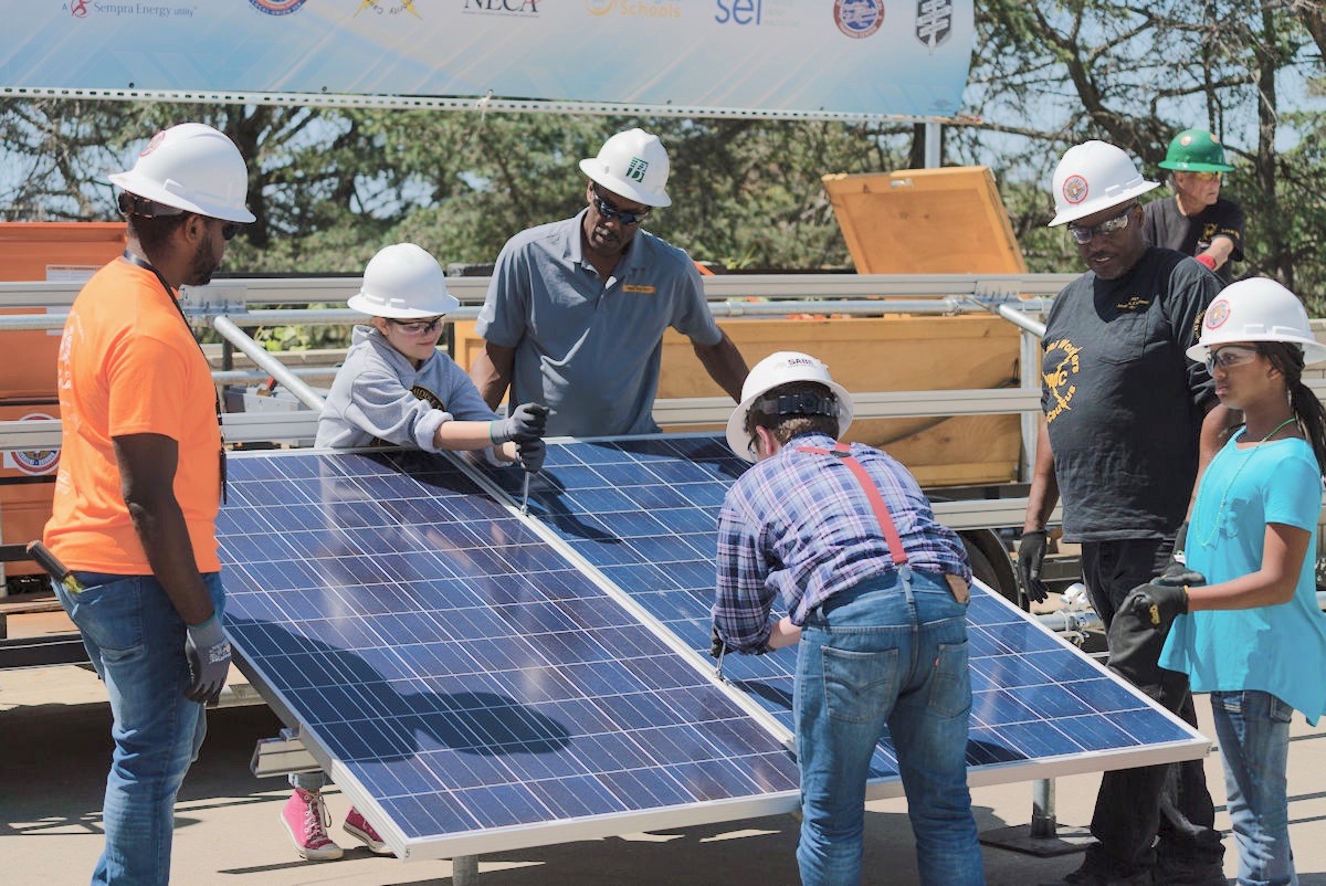 Local San Diego kids working hand-in-hand with members of the International Brotherhood of Electrical Workers (IBEW) to construct a working solar car charging station. (PHOTO by Baker Electric Solar)
