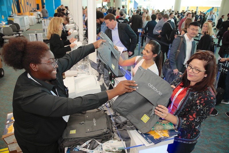 Attendees at the BIO International Convention collect swab bags from a vendor in the San Diego Convention Center.