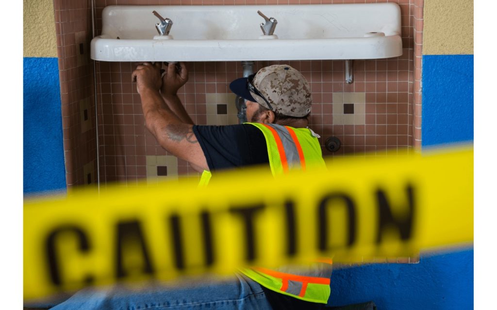 Los Angeles Unified School District plumber Daniel Wills repairs and replaces one of hundreds of old fountains found to have high levels of lead — this one at John H Francis Polytechnic Senior High in Sun Valley. (Photo by Nancy Pastor for CALmatters)