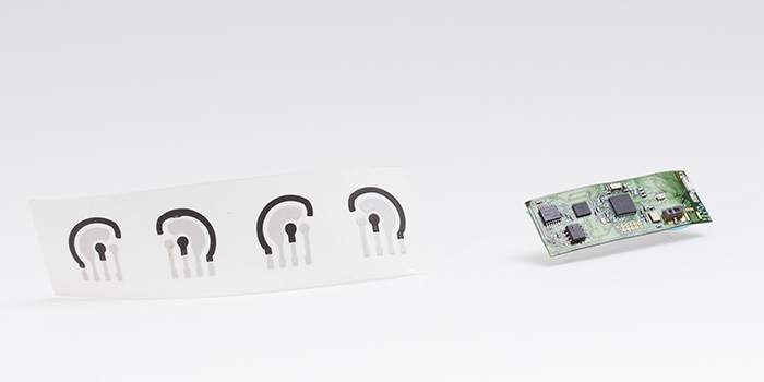 The alcohol sensor consists of a temporary tattoo (left) developed by the Wang lab and a flexible printed electronic circuit board (right) developed by the Mercier lab.