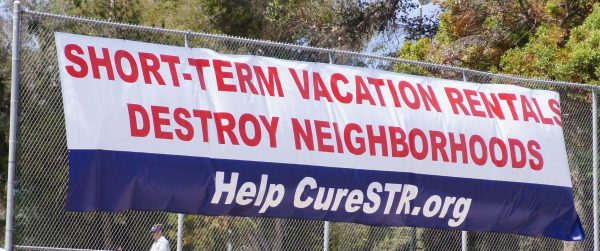 Banner on a San Diego fence gives an opposing view on short-term rentals.