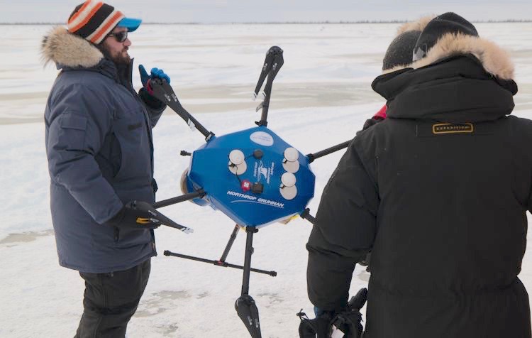 Operation #PolarEye team members walk their custom hexacopter to the launch site on the Hudson Bay. (Credit: Northrop Grumman)