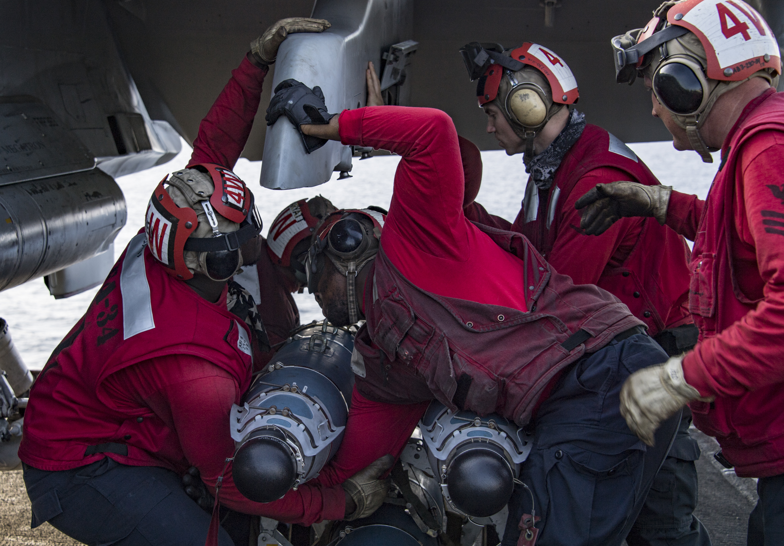 Sailors attach ordnance to an F/A-18C Hornet assigned to the “Blue Blasters” of Strike Fighter Squadron 34 on the flight deck of aircraft carrier USS Carl Vinson. The Carl Vinson Strike Group is currently operating in the Western Pacific as part of a regularly scheduled deployment. (U.S. Navy photo by Mass Communication Specialist 3rd Class Dylan M. Kinee)