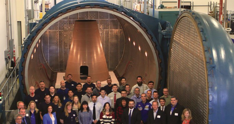 Employees at San Diego Composites in 2016 showcase their 16-foot diameter, 30-foot long autoclave and a completed shipset of Launch Abort System Fillet panels to Orion delegates from NASA and Lockheed Martin. (Photo Credit: San Diego Composites Inc.)