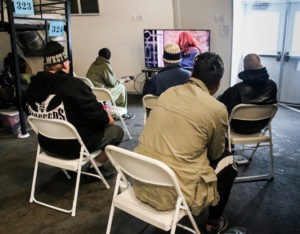 In one of the homeless shelters, residents relax watching TV. (Photo by Brennan Scott)
