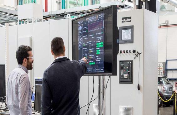 Officials examine the electric vehicle-to-microgrid-utility grid test screen at Marine Corps Air Station Miramar. (Photo courtesy of the National Renewable Energy Lab)