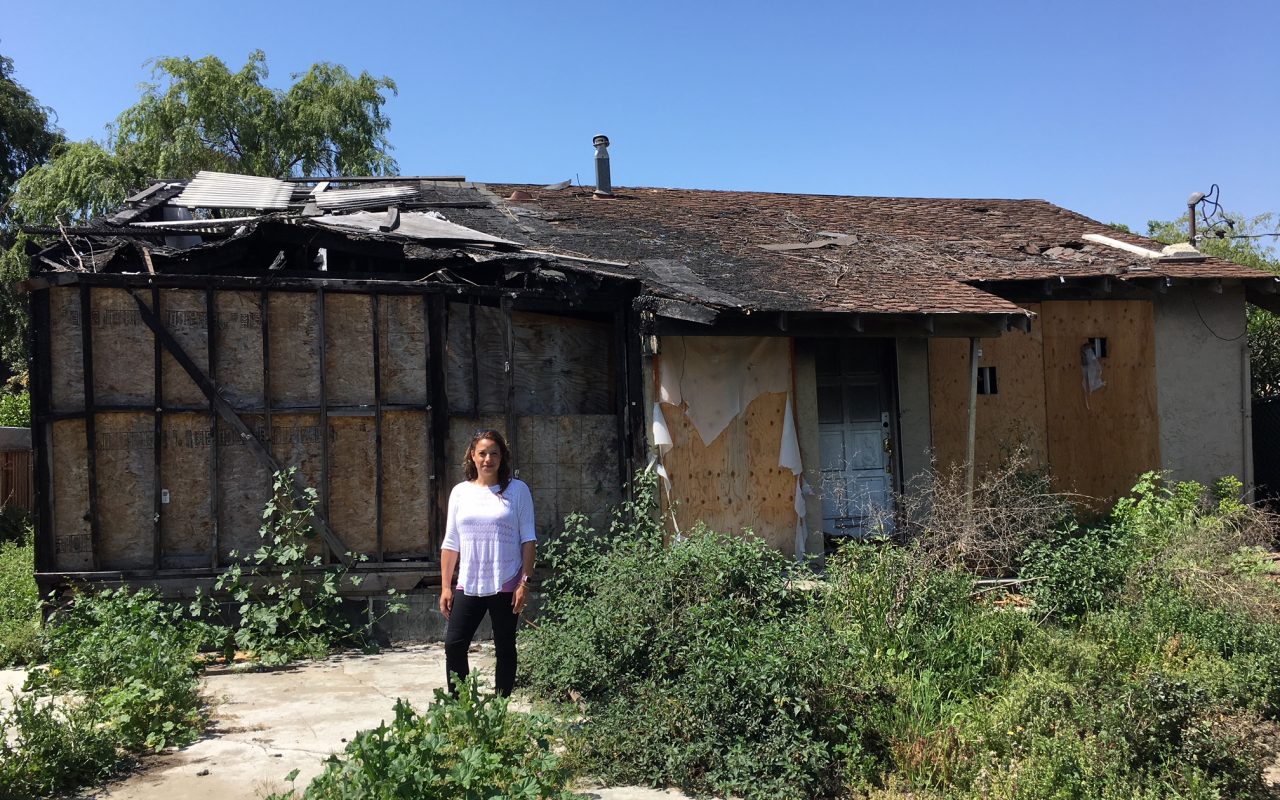 San Jose Realtor Holly Barr stands outside the burned-out house she sold for more than $900,000.(Credit: Matt Levin, CALmatters)