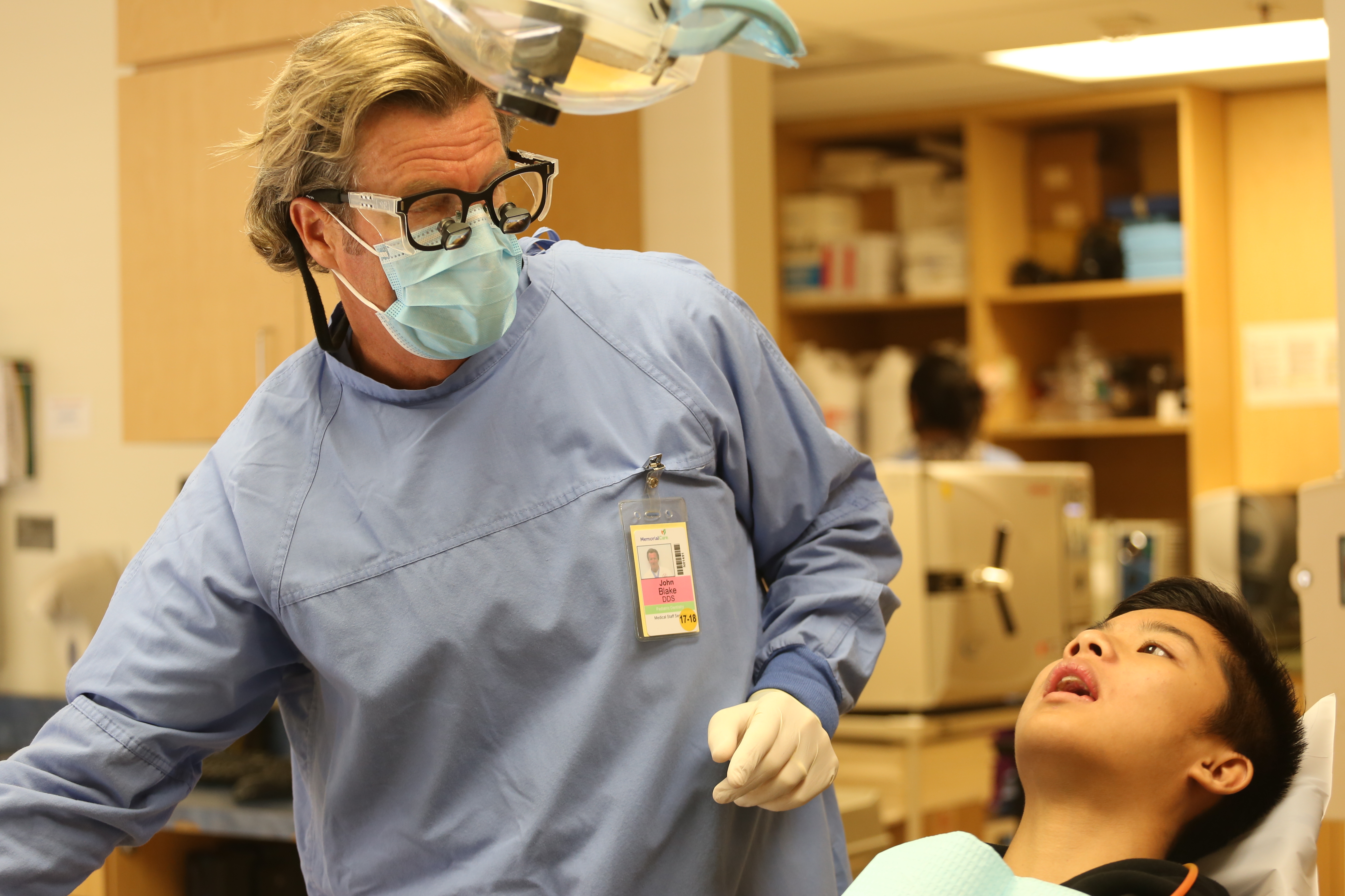 Long Beach dentist John Blake with patient Nelson Phan. (Photo by IrisSchneider for CALmatters)