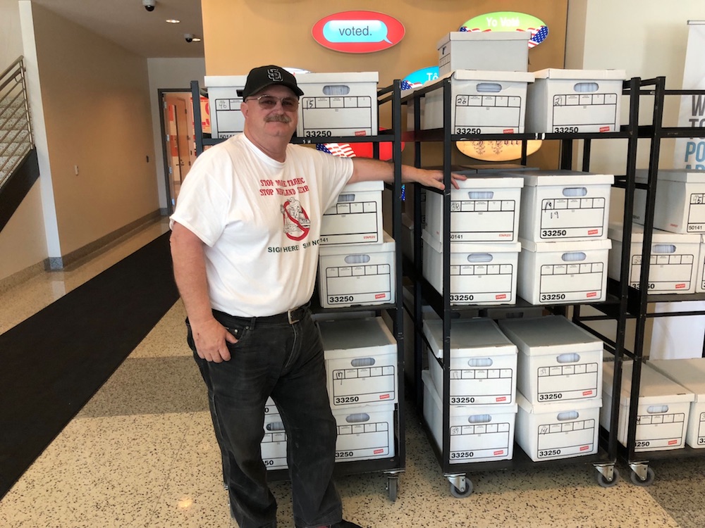 Bob Glaser of the Committee Against Newland Sierra and Bad Development with boxes of petitions delivered to the Registrar of Voters. 