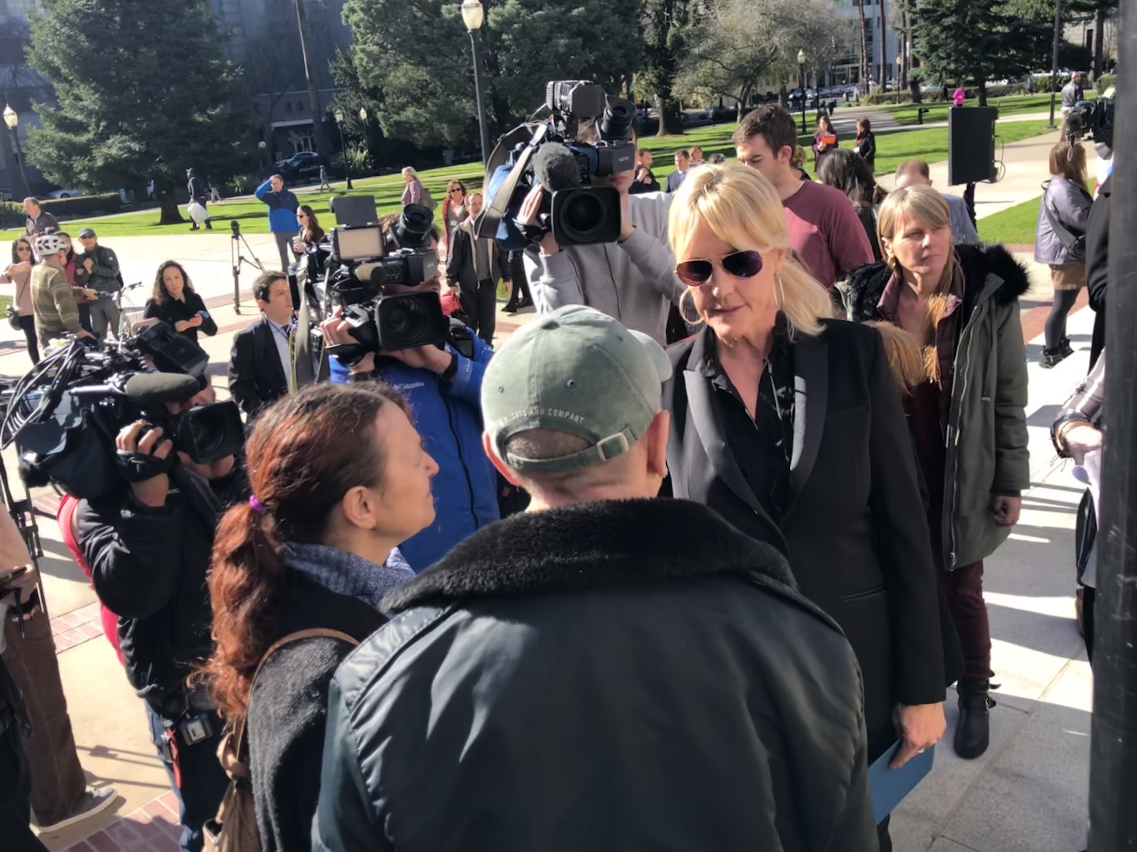 Erin Brockovich speaks to Paradise wildfire victims Victor Porter and Beth Hoffman on Jan. 22. (Photo by Judy Lin, for CALmatters)