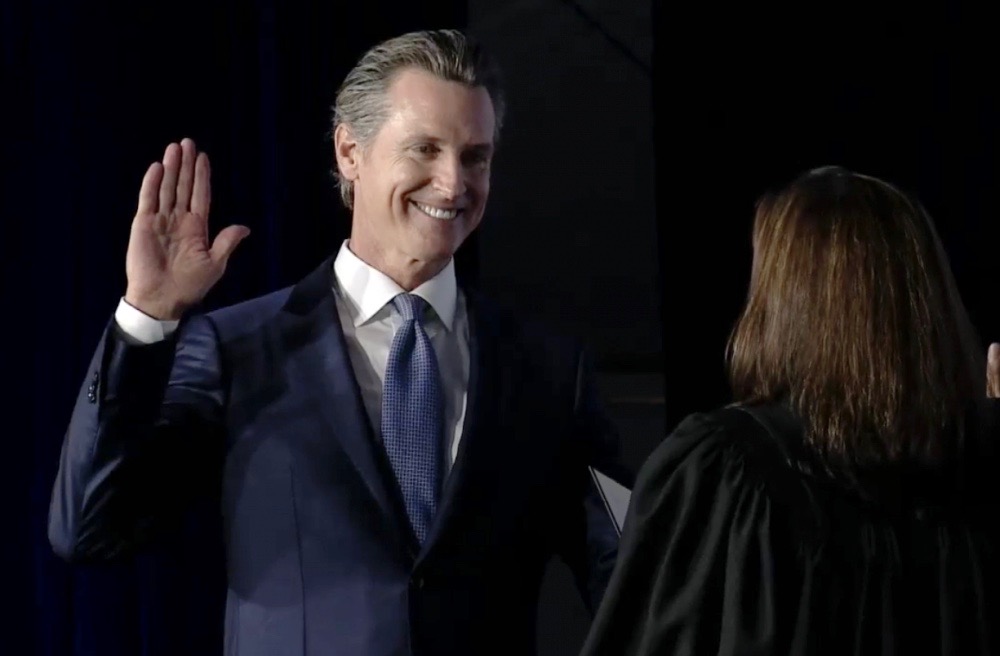 Gov. Gavin Newsom takes the oath of office from California Chief Justice Tani Cantil-Sakauye in Sacramento on Monday. (Photo for CALmatters by Randy Pench)