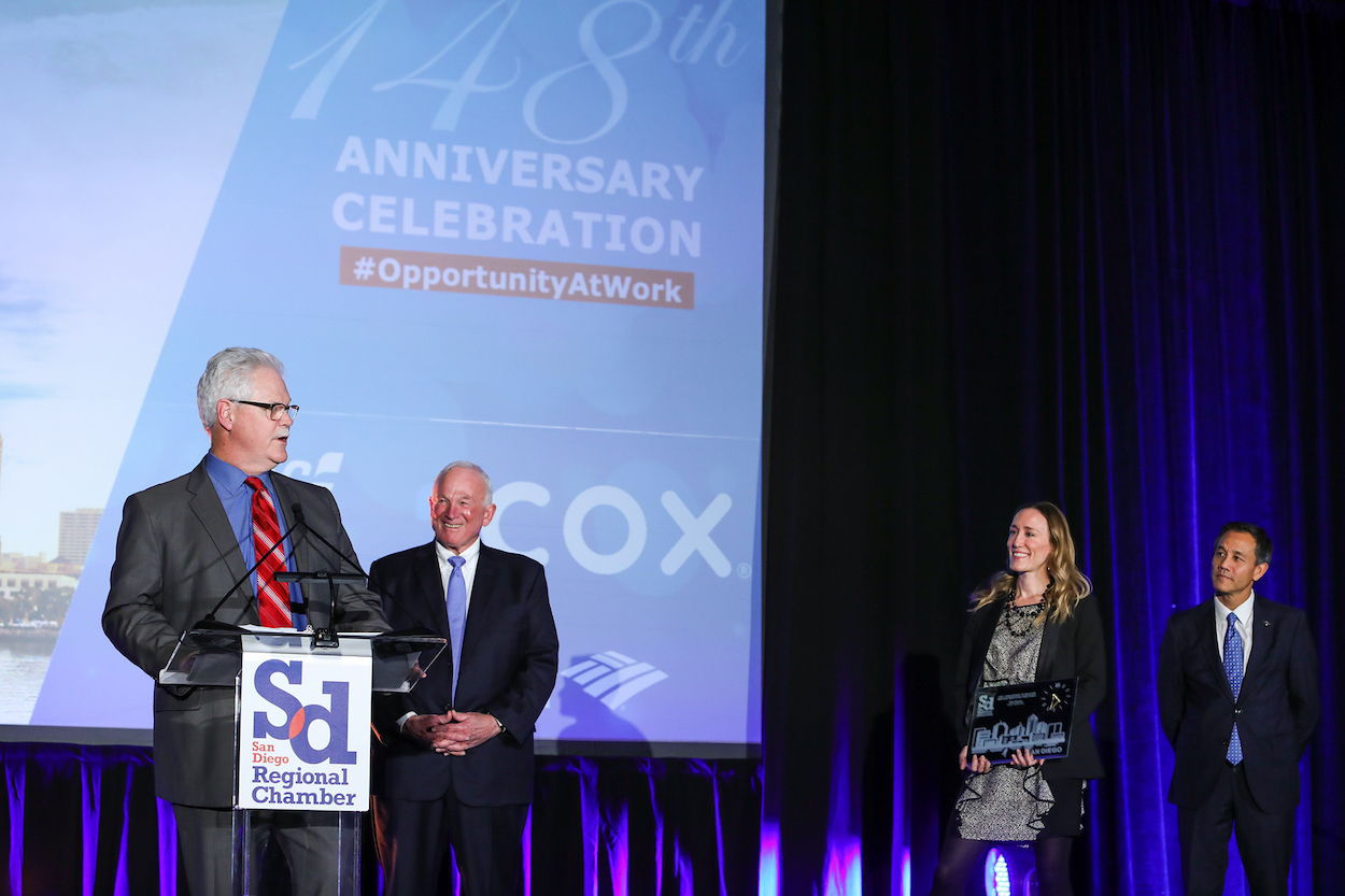 Herb Klein Spirit of San Diego award winner Mike Murphy, president and CEO of Sharp HealthCare (at podium), with Chamber CEO Jerry Sanders, Erin Stafford, vice president of marketing for Aya Healthcare, and Rick Bregman, 2019 Chamber board chair.