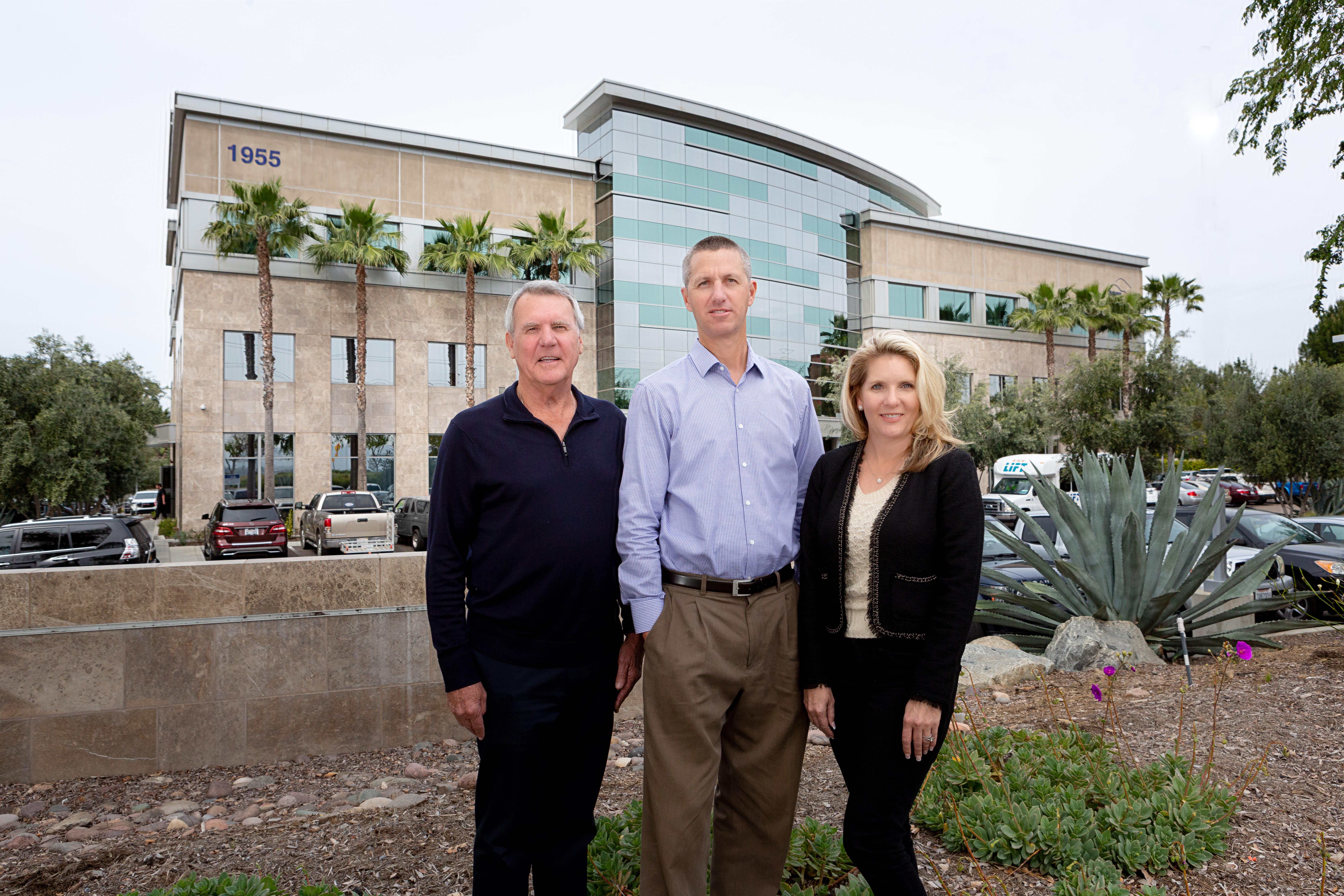 Doug Barnhart (left) has a passion for building and philanthropy — qualities carried on by his daughter, Tami Barnhart-Reese, and son-in-law West Reese, shown outside a Barnhart project, the Makina Medical Center. (Photo by Pam Davis)