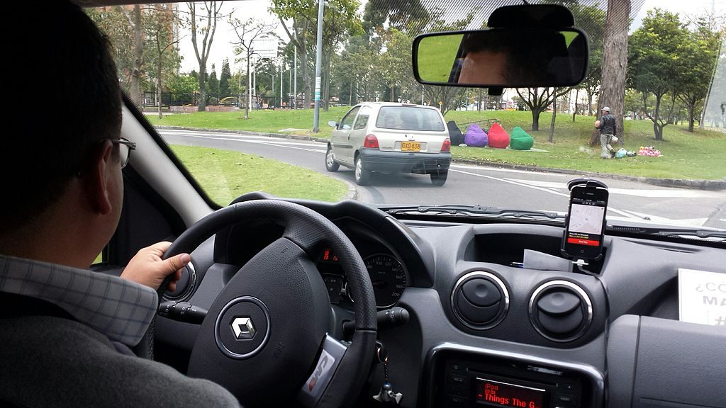 An Uber drives gives a passenger a ride. (Photo by Alexander Torrenegra via Wikimedia Commons)