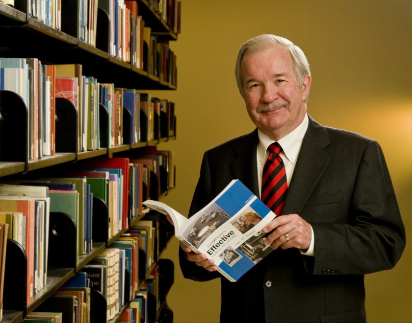 Glen Broom holding “Effective Public Relations,” a widely used textbook he co-authored. ( Photo courtesy of San Diego State University)