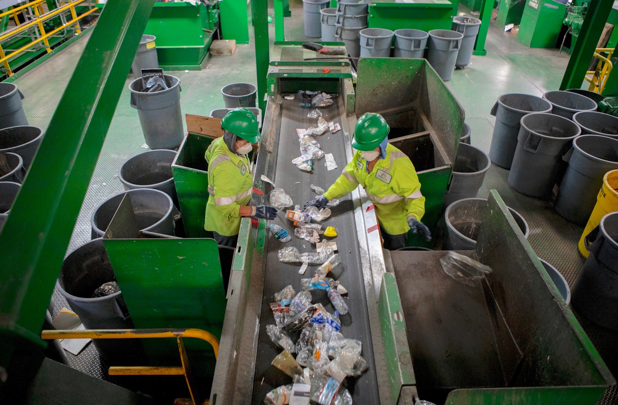 GreenWaste Recovery employees sort through plastic items on a conveyor belt at the company’s materials recovery facility in San Jose, California. Photo by Anne Wernikoff for CalMatters, July 29, 2019.