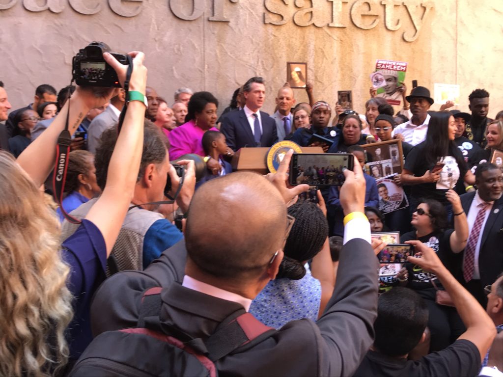 Gov. Gavin Newsom and crowd at signing ceremony for police use-of-force legislation. (Photo by Dan Morain for CalMatters)