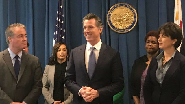 Gov. Gavin Newsom is flanked by charter school legislation authors Sen. Connie Leyva and Assemblyman Patrick O’Donnell. (Photo for CalMatters by Ricardo Cano)