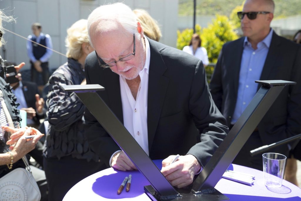 Dan Epstein signs a ceremonial beam during a May 24 topping off ceremony to celebrate the near-completion of the newly expanded Veterans Center. (Photo by Andrew Reed)