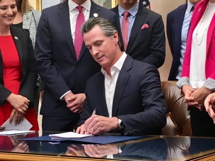 Gov. Gavin Newsom signs gun-control legislation on Oct. 11, 2019. (Photo by Laurel Rosenhall/CalMatters)