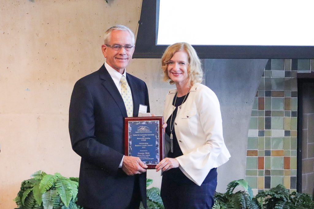 George Weir receives his award from Cal State San Marcos President Ellen Neufeldt. (Photo courtesy of CSUSM)
