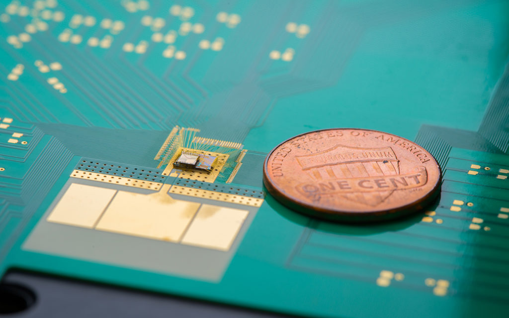 By only waking up a wireless device when necessary, the wake-up receiver (chip stack to the left of the penny) can cut down on power use and extend battery life. (Photo by David Baillot/UC San Diego Jacobs School of Engineering)