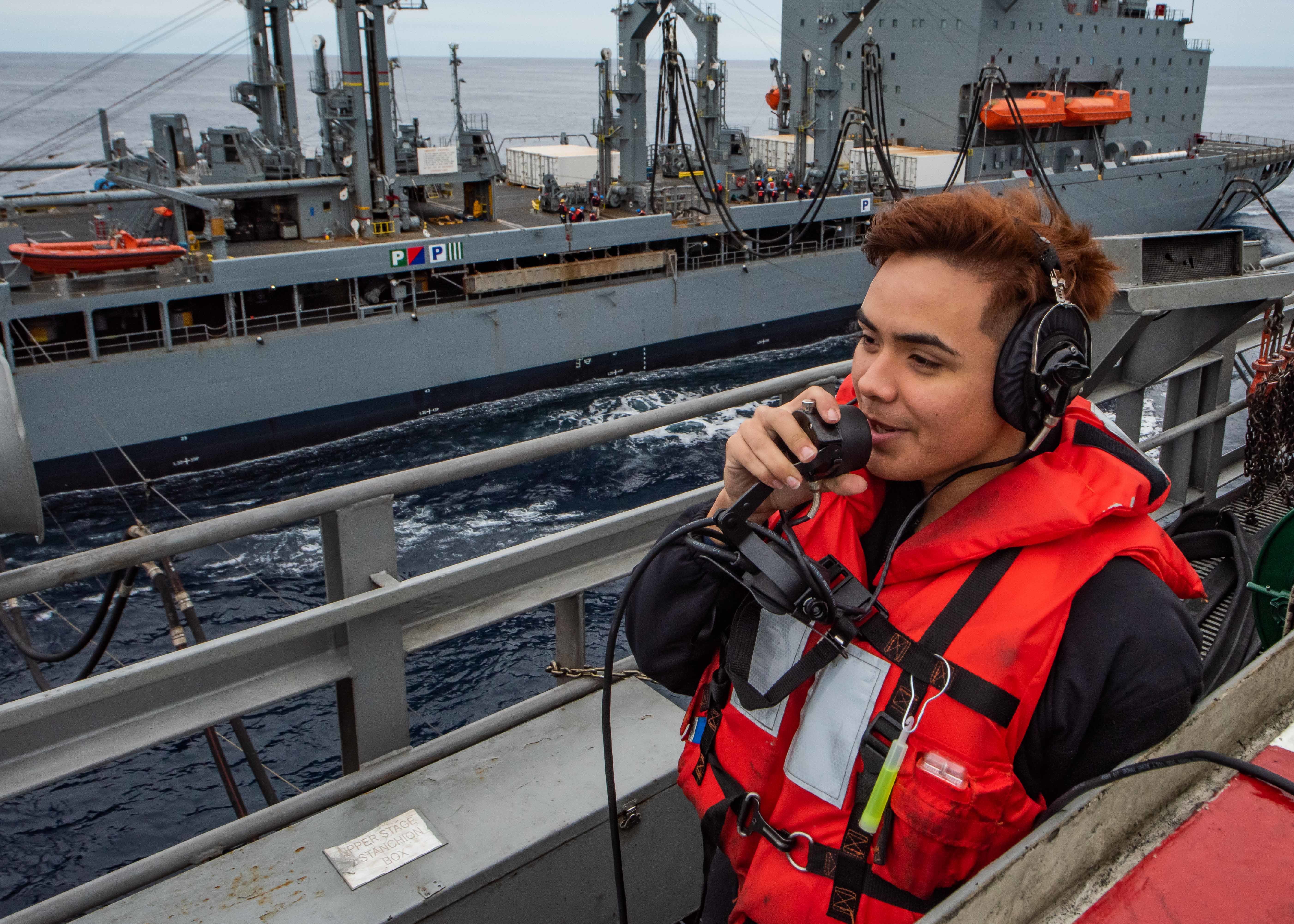 PACIFIC OCEAN --Seaman Shelbyan Diaz, from Harlingen, Texas, uses a sound-powered telephone to report the distance between the aircraft carrier USS Theodore Roosevelt and the Military Sealift Command fleet replenishment oiler USNS Yukon Dec. 3, 2019. Theodore Roosevelt is underway conducting routine training in the eastern Pacific Ocean. (U.S. Navy photo by Airman D.J. Schwartz)