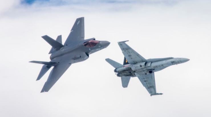 An F-35C Lightning II (left) and venerable F/A-18 Hornet in flight during training near Lemore in 2019. (U.S. Marine Corps photo)