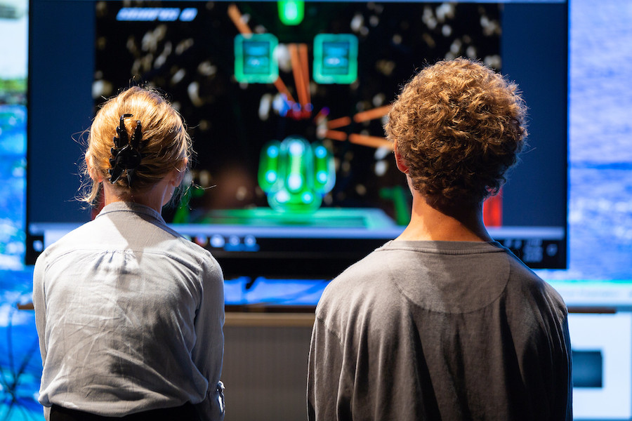 Young audience members take their turn to try out a two-person eye tracking game created by a team of PoNG interns (August 2018. Courtesy of UC San Diego).