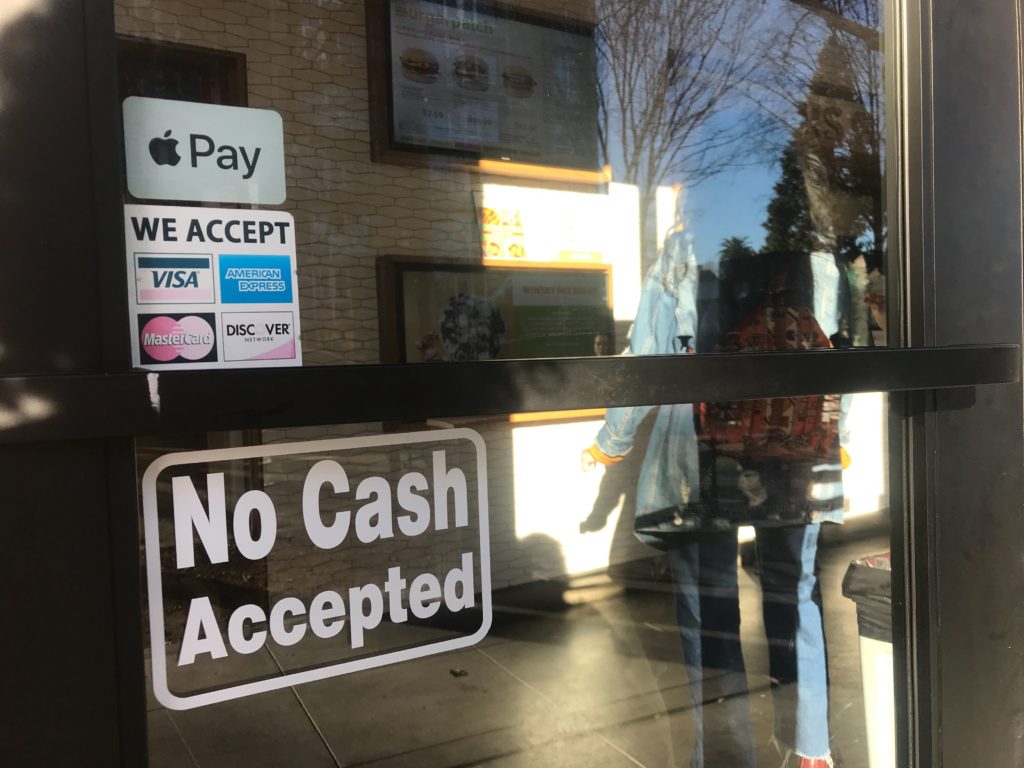 Burger Patch hasn't taken down the ‘No Cash Accepted’ sign on its front door, even though it begin accepting cash about a month after opening last May. The vegan burger joint is still ‘card-preferred,’ said employee Zia Simmons. (Photo by Jackie Botts for CalMatters)