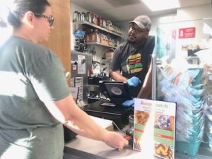 A customer pays with a credit card at Burger Patch, a vegan burger joint in Sacramento. (Photo by Jackie Botts for CalMatters)