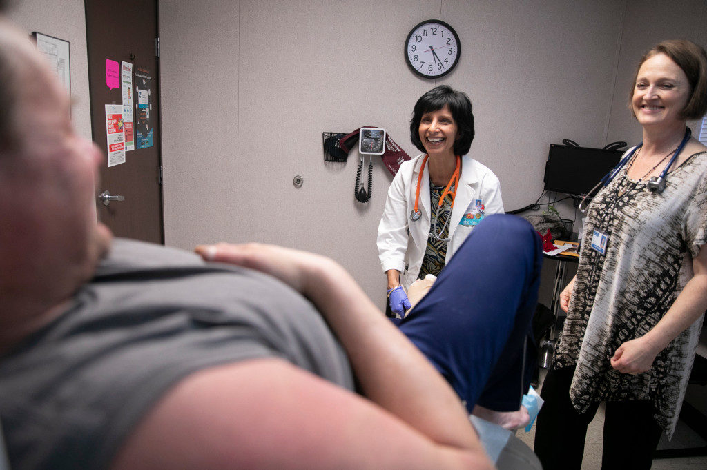 Nurse Practitioner Surani Hayre-Kwan, left, and nurse practitioner student Kristina Crichton during an office visit with patient John Donaldson, a Guerneville resident who relies on Hayre-Kawn as his primary care physician. (Photo by Anne Wernikoff for CalMatters)