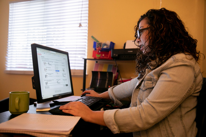 Maria Garcia, at home in Antioch, works her way through a Calbright cyber security course. Her goal is to get a certificate from the first-of-its-kind addition to the community college system, she says, but recent setbacks at Calbright have made her wonder whether its future is secure. (Photo by Anne Wernikoff for CalMatters)