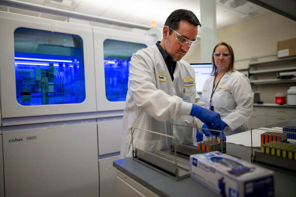 Marcelo Prado and Katie Zegarski of UC Davis Health load coronavirus samples onto trays. (Photo courtesy of UC Davis)