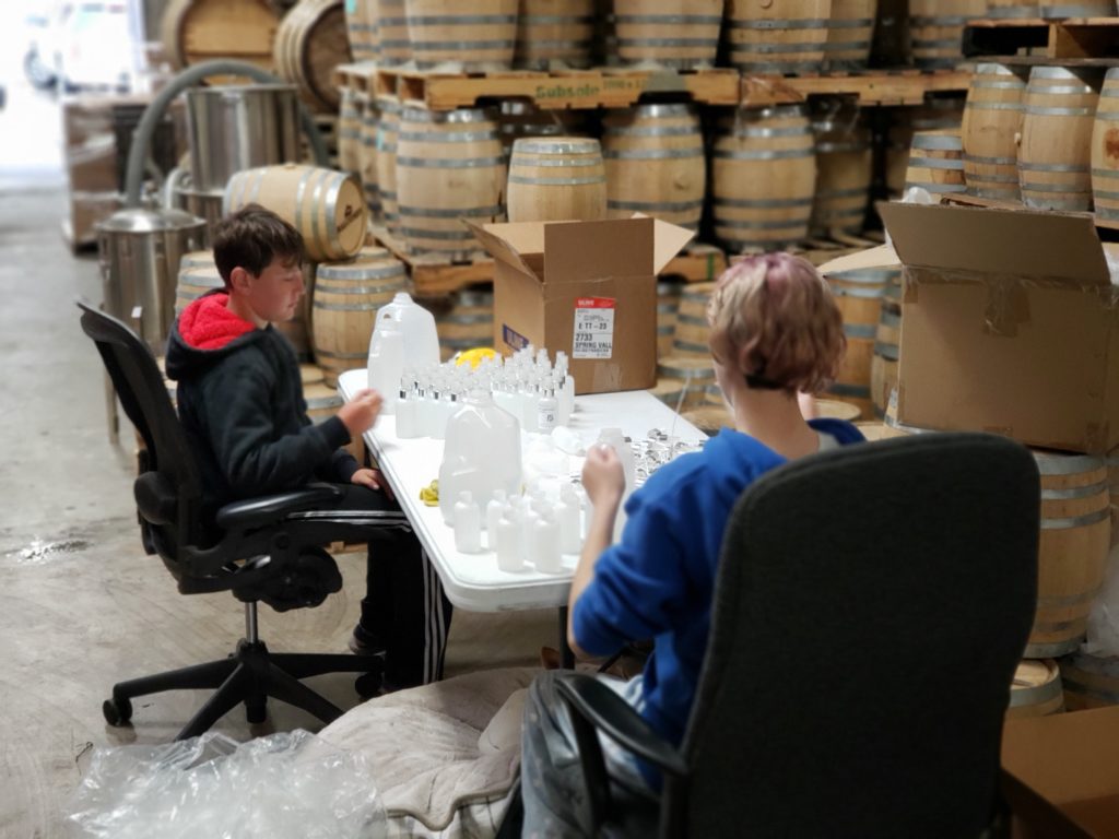 Family members help with bottle hand sanitizers at Liberty Call Distilling. (Photo courtesy of Liberty Call Distilling.