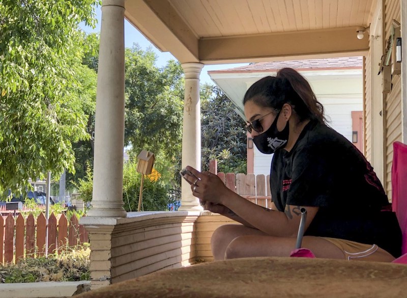 Gabriella Aldana, 24, rests on the front porch of the house she rents in Riverside on Aug. 7. Aldana has been moving houses since she and her two children were evicted from an apartment on March 26.