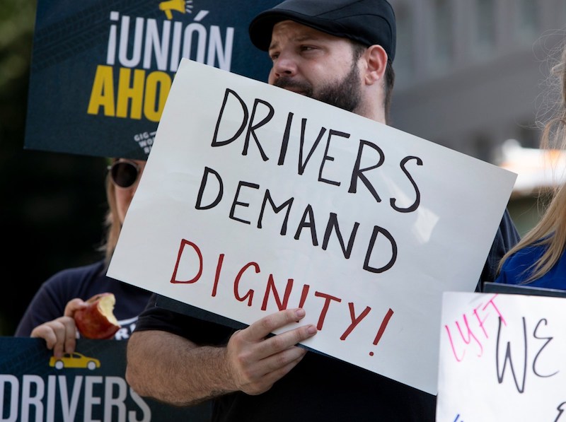 Protesters carrying signs supporting AB-5, a new law that changed the employment classification for gig workers such as Uber and Lyft drivers. (Photo by Anne Wernikoff for CalMatters)