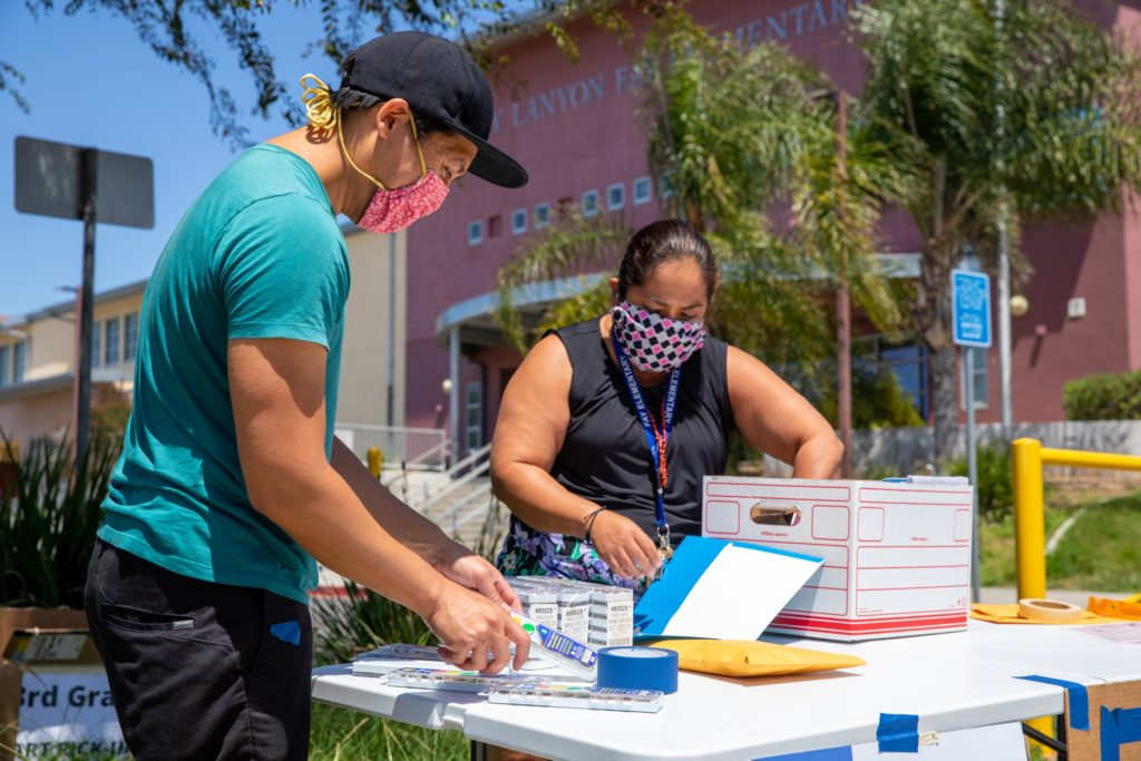 (Photo: Museum staff hands out at-home art-making supplies. Photographer Ron Kerner)