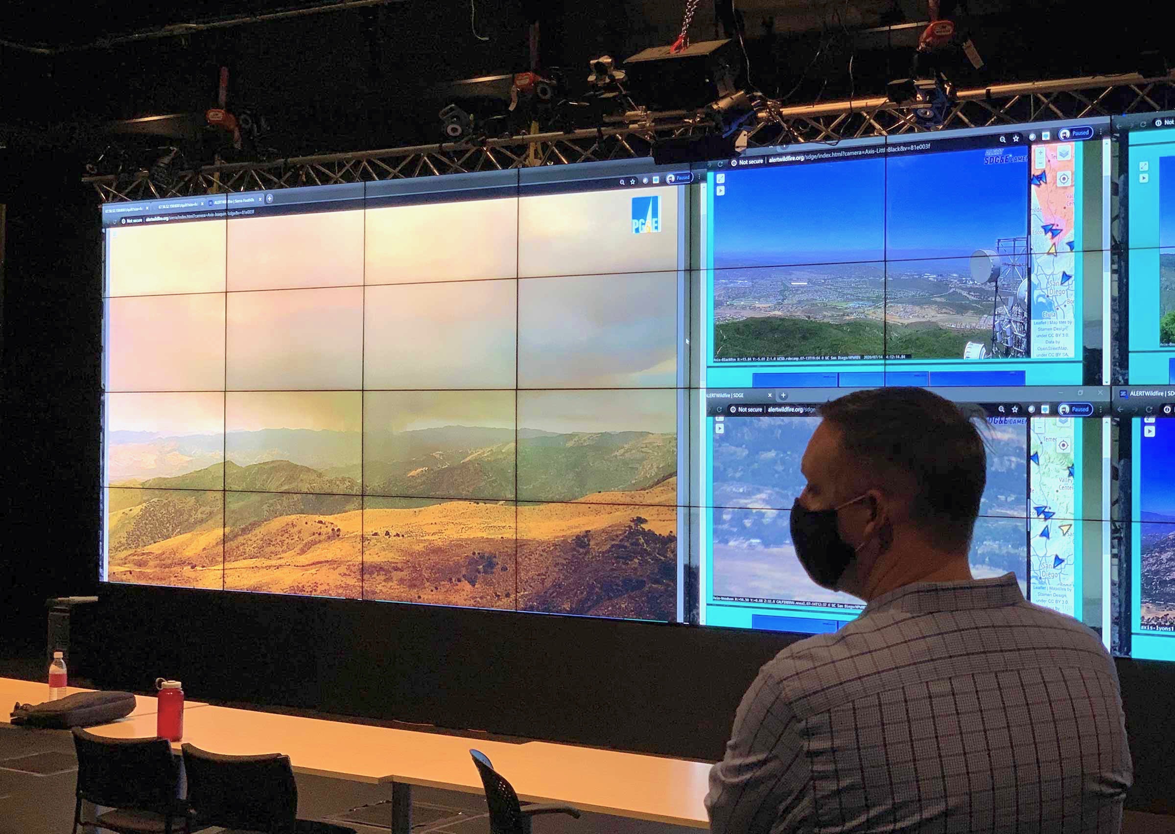 A first responder observing real-time ALERTWildfire camera network feeds in UC San Diego’s VRroom, a room-scale visual analytics environment for collaborative big-data analytics.
