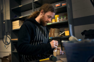 Broken Token employee John Marshall works on a game piece.